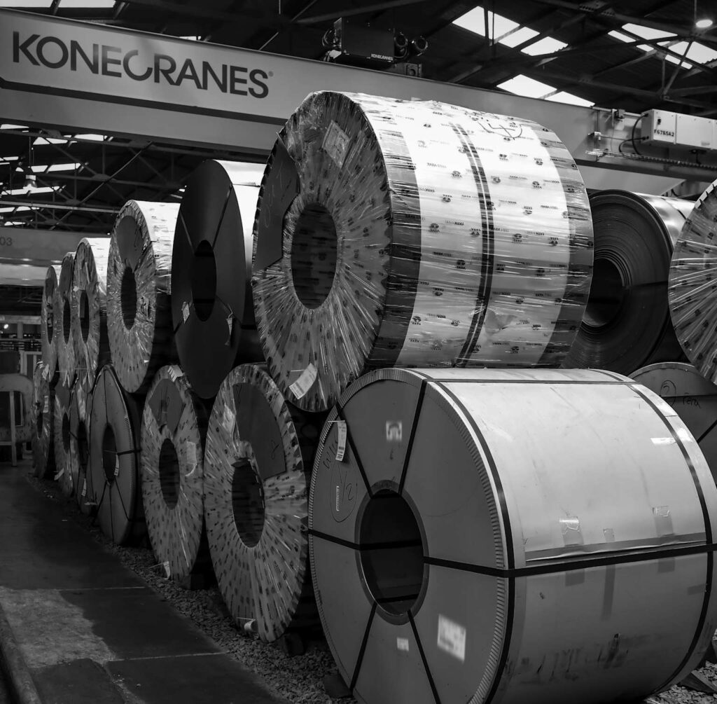 Steel coil inventory in processing facility — raw material represents up to 75% of production cost